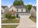 Charming two-story home featuring a brick and siding exterior with a well-maintained lawn and landscaping at 176 Jennymarie Rd, Mooresville, NC 28115