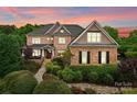 Striking two-story brick home featuring a stone accent, manicured landscaping, and a welcoming front porch perfect for relaxing at 2304 Thunder Gulch Ct, Waxhaw, NC 28173