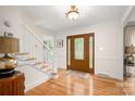Welcoming foyer with hardwood floors, a wooden front door with glass insets, and a staircase with white banisters at 2306 Beechwood Dr, Waxhaw, NC 28173