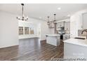 Open-concept kitchen with stainless steel appliances, grey cabinets, quartz countertops and hardwood floors at 2311 Bulwarks Ct # 3P, Albemarle, NC 28001