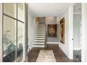 Spacious foyer with hardwood floors, staircase, and decorative art creating an inviting entrance at 2541 Kenmore Ave, Charlotte, NC 28204