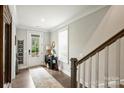 Bright foyer with hardwood floors, a white front door, and a staircase leading to the upper level at 2541 Kenmore Ave, Charlotte, NC 28204