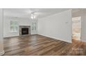 Spacious living room with wood floors, stone fireplace, ample natural light, and a ceiling fan at 2710 Red Bud Ln, Fort Mill, SC 29715