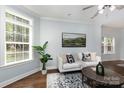Comfortable living room featuring a white sofa, hardwood floors, and natural light from large windows at 3004 Point Clear Dr, Tega Cay, SC 29708