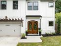 Inviting front entrance with wood double doors, a concrete walkway, and manicured landscaping at 3505 Trent St, Charlotte, NC 28209