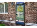 Close-up of a front door featuring glass and brick, with the house number visible at 413 Nobles Way, Belmont, NC 28012