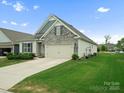 Well-maintained home featuring a stone facade, two-car garage, and lush green lawn with manicured landscaping at 5058 Antebellum Dr, Iron Station, NC 28080