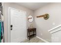 Bright entryway with wood-look flooring, decorative mirror and coat rack at 5257 Glenlea Walk Ln, Charlotte, NC 28216