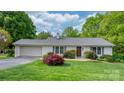 Charming single-story home with a well-manicured lawn, mature trees, and a brick exterior at 5486 Suttlemyre Ln, Hickory, NC 28601