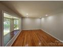 Spacious living room with gleaming hardwood floors and a large bay window at 6212 Snowcrest Ct, Charlotte, NC 28212