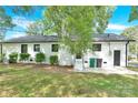 A view of the backyard with manicured bushes and a door leading into the home at 6600 Knightswood Dr, Charlotte, NC 28226