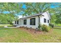 Side view of a well-maintained home featuring classic shutters and lush landscaping at 6600 Knightswood Dr, Charlotte, NC 28226