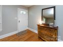 Foyer with hardwood floors and a wooden dresser with mirror at 6616 Williams Rd, Charlotte, NC 28215