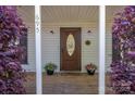 Inviting front door with decorative glass, framed by lush greenery and potted flowers, creating a warm welcome at 695 Linwood Rd, Mooresville, NC 28115