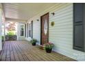 Charming front porch featuring a decorative door, seasonal flowers, and classic architectural details at 695 Linwood Rd, Mooresville, NC 28115