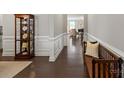 Elegant hallway with dark hardwood floors, white wainscoting, and a decorative display cabinet at 7039 Chrysanthemum Rd, Lancaster, SC 29720