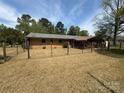 The backyard features a covered patio, fenced yard, and mature trees at 785 Nc Highway 109 N Hwy, Troy, NC 27371