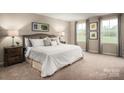 Comfortable main bedroom features soft carpeting, neutral walls, and natural light from two windows at 00123 Millstream Dr, China Grove, NC 28023