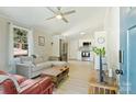 Bright living room with modern fan, sectional couch, hardwood floors, and connecting kitchen at 1104 Norris Ave, Charlotte, NC 28206