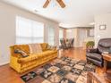 Cozy living room featuring hardwood floors, a ceiling fan, and comfortable seating. A connected dining area is visible at 113 Rocky Trail Ct, Fort Mill, SC 29715