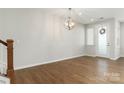 Bright living room with wood floors, modern lighting fixture, and a welcoming front door at 131 Berkeley Ave # D, Mooresville, NC 28117