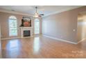 Spacious living room with wood floors, arched windows, and a cozy fireplace at 134 Walmsley Pl, Mooresville, NC 28117