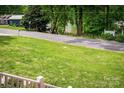 Scenic street view showing lush green lawn, mature trees, and glimpses of the nearby lake at 141 Culpeze Rd, Mooresville, NC 28117