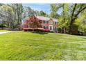 Beautiful brick home with well-manicured lawn, mature trees, and vibrant landscaping enhancing its curb appeal at 14812 Stonegreen Ln, Huntersville, NC 28078