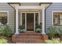 Inviting front entrance with brick steps, white columns, and elegant potted plants at 1726 The Plz, Charlotte, NC 28205