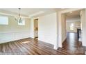A bright dining room features wainscoting, tray ceilings, wood floors, and a modern chandelier at 2012 Embassy Ct # 46, Charlotte, NC 28213