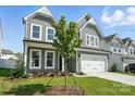 Charming two-story home featuring gray siding, white trim, a two-car garage, and a well-maintained lawn at 2012 Embassy Ct # 46, Charlotte, NC 28213