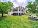 Beautiful home exterior boasting a spacious porch, manicured lawn, and decorative garden elements at 206 Montclair Dr, Locust, NC 28097