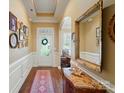Elegant foyer with hardwood floors, decorative mirror, and a view of the front door and entryway at 2119 Augusta National Dr, Denver, NC 28037