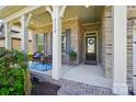 View of the front porch with brick columns and a seating area with blue patterned rug at 2119 Augusta National Dr, Denver, NC 28037