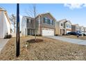Two-story gray home, brick accents, a two-car garage, driveway, and minimal landscaping in a neighborhood setting at 2120 Redstone Dr, York, SC 29745