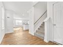 Bright foyer featuring wood floors, carpeted stairs, and a view into a living space with bar seating at 2120 Redstone Dr, York, SC 29745