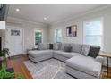 Cozy living room features a large gray sectional, hardwood floors, and neutral walls, creating a welcoming atmosphere at 2124 Roslyn Ave, Charlotte, NC 28208