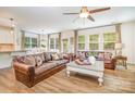 Open concept living area with wood floors, ceiling fan, lots of natural light, and stylish leather sofas at 2158 Winhall Rd, Fort Mill, SC 29715
