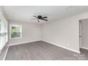 Bright bedroom with sleek gray flooring, complemented by a modern ceiling fan and large window at 221 Belton Ave, Mount Holly, NC 28120