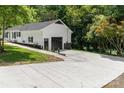 Home boasts an extended driveway leading to a garage, complemented by fresh landscaping at 221 Belton Ave, Mount Holly, NC 28120