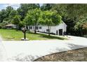 Inviting ranch-style home featuring a long driveway, an attached garage, and a well-manicured lawn at 221 Belton Ave, Mount Holly, NC 28120