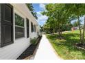 Landscaped side yard featuring a white gravel path, lush greenery, and appealing exterior details at 221 Belton Ave, Mount Holly, NC 28120