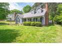 Attractive home featuring gray siding, brick chimney, and a lush green lawn with trimmed shrubbery at 2439 Caswell Ct, Gastonia, NC 28054