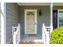 Close-up of the front door with glass and white trim and welcoming shrubbery at 2439 Caswell Ct, Gastonia, NC 28054