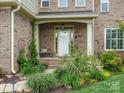 Charming front porch with brick columns, lush plants, and a cozy bench at 246 Mcduffie Ln, Fort Mill, SC 29715
