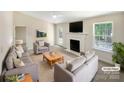 Bright, virtually staged living room with a fireplace, neutral tones, and comfortable seating arrangement at 2512 Captains Watch Ne Rd, Kannapolis, NC 28083