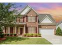 Charming two-story brick home featuring a well-manicured lawn, red shutters and a two-car garage at 3005 Sandbox Cir, Indian Trail, NC 28079
