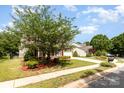 Charming two-story home with manicured lawn, red shutters and a lush tree in the front yard at 3005 Sandbox Cir, Indian Trail, NC 28079