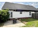 Rear view of a fire-damaged house with white siding, patio, and partially fenced yard at 3205 Creek Trail Rd, Indian Trail, NC 28079