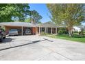 Charming brick home featuring a covered carport, front porch, and beautiful, mature landscaping in a suburban setting at 3265 W Innes St, Salisbury, NC 28144
